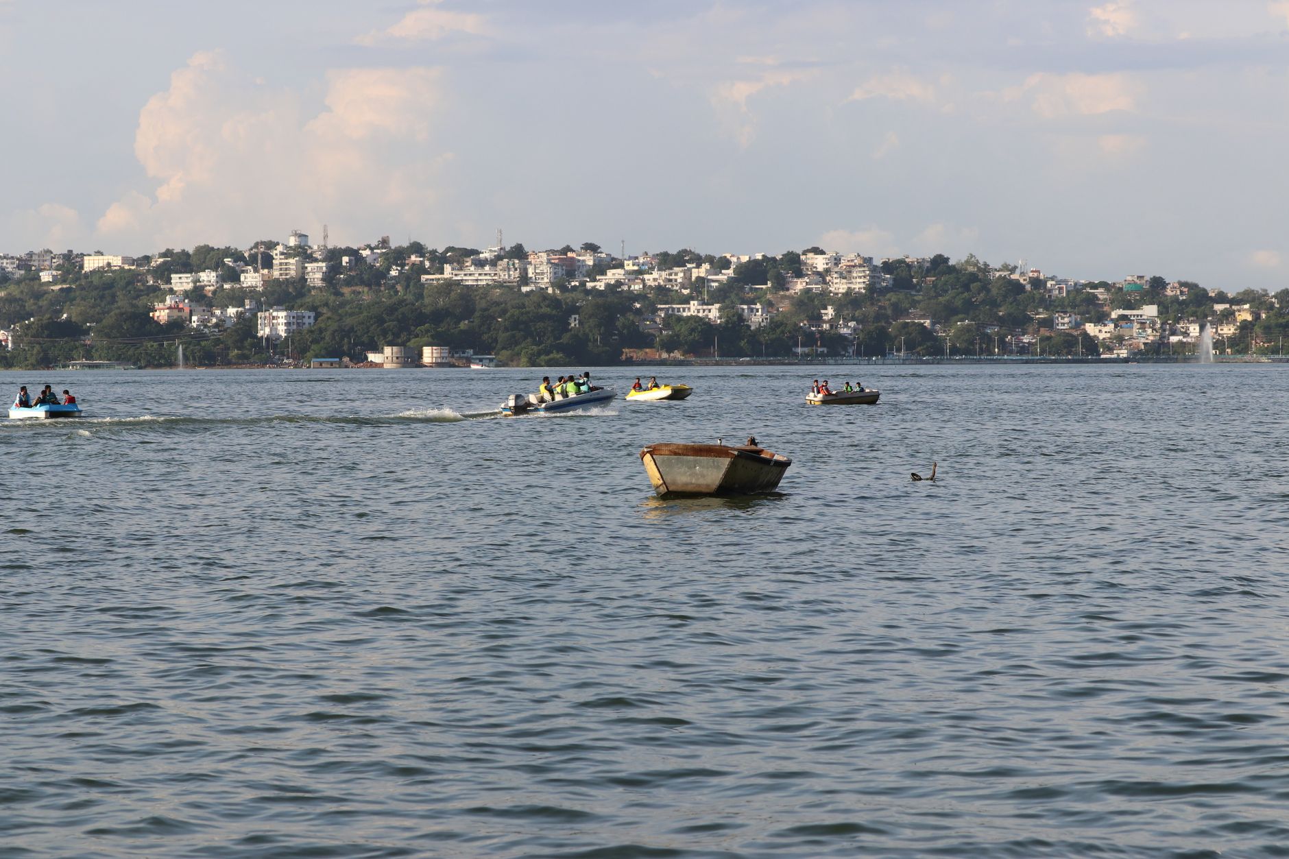 Boats on Upper Lake in Bhopal with the city skyline behind